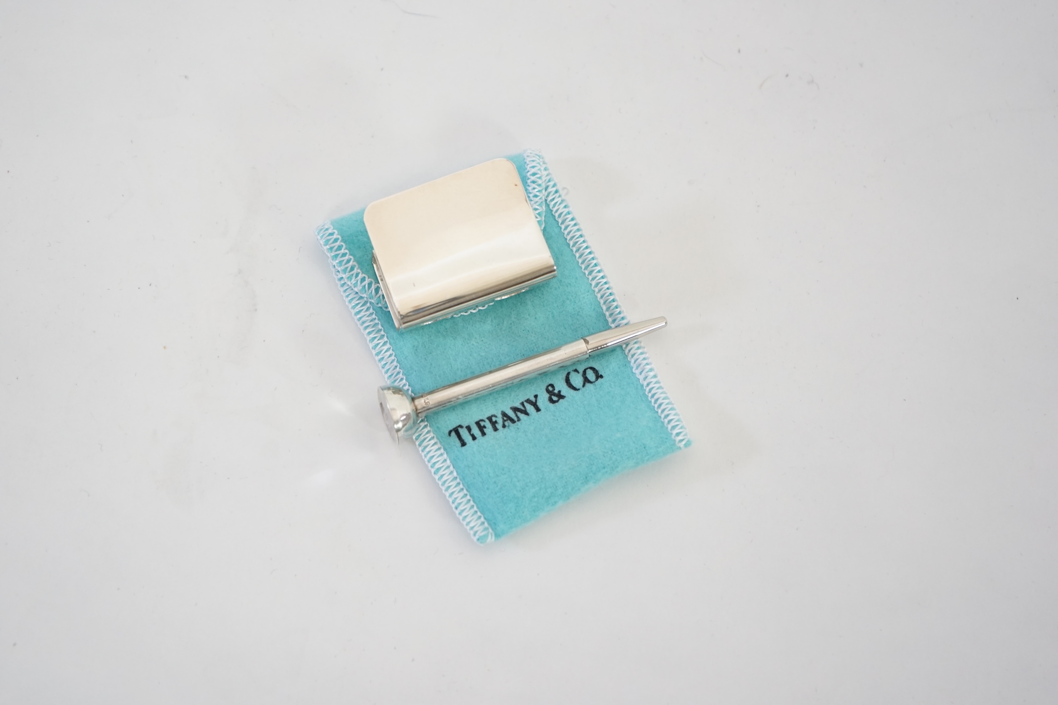 A Tiffany & Co. golf tee holder and pencil